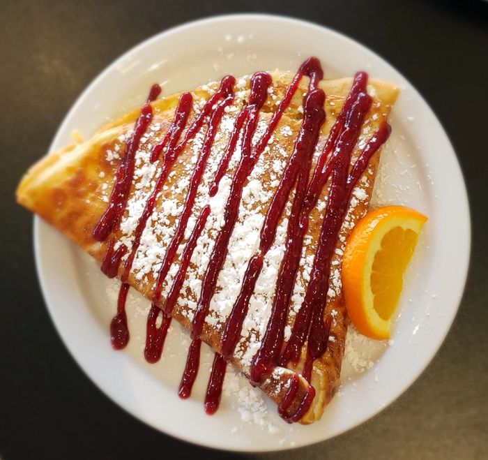 The monte cristo crepe is garnished with organic raspberry preserves. 