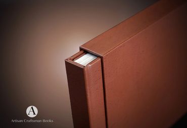 Close-up of a brown leather-bound book with Artisan Craftsman Books logo.