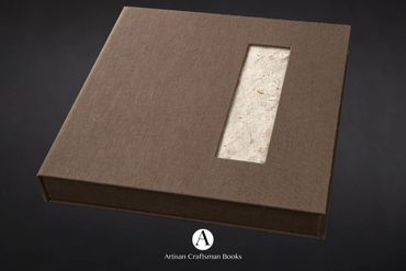 Brown handcrafted book with a textured cover and a rectangular window.