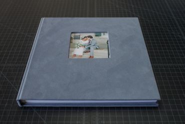 Gray wedding photo album with a couple's picture on the cover.