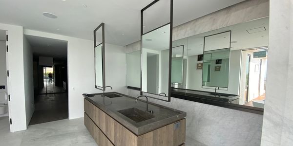 Modern bathroom with dual sinks, large mirrors, and wooden cabinetry.