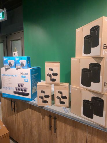 Boxes of HiLook cameras and Sonos products on a countertop.