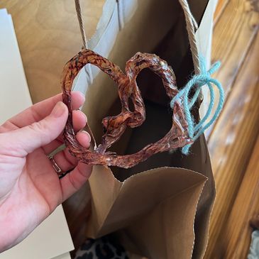 A heart shaped cord keepsake going into a paper bag