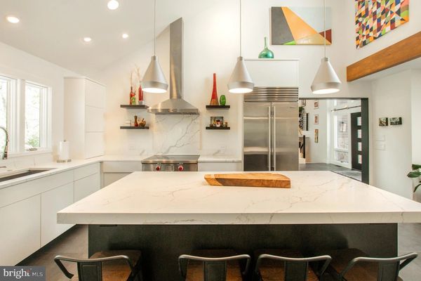 Modern kitchen with marble countertops and stainless steel appliances.