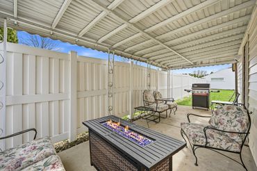 Covered patio with fire table, ample seating and new gas grill.
