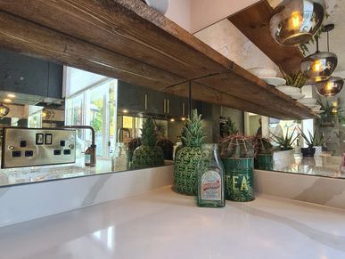Stylish kitchen featuring a tinted mirror splashback, adding depth and a modern touch to the space.