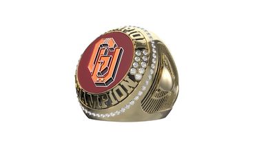 A gold championship ring with a red emblem and diamond accents.
