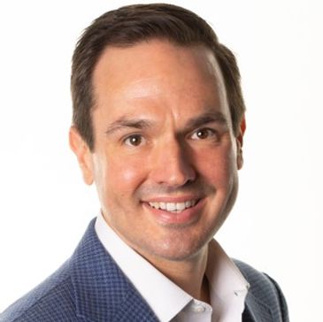 Professional smiling man in a blue suit jacket.