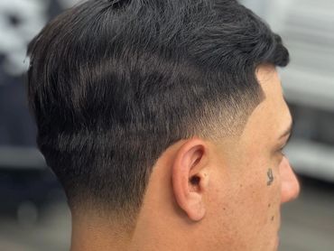 Fresh fade haircut with a clean, sharp line-up on a young man.