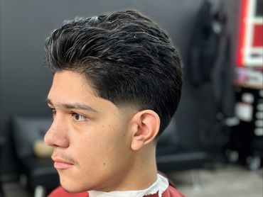 Young man with a fresh haircut at a barber shop.