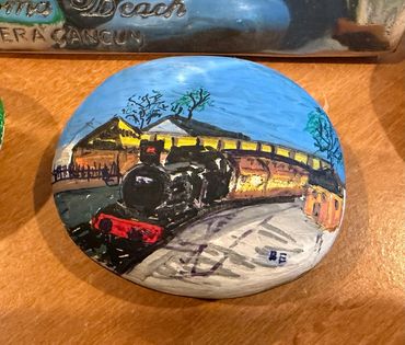 A hand painted rock of the Winchcombe steam train celebrating railway adventures and the joy of disc