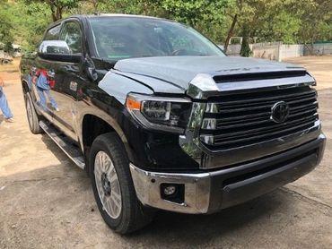 Black pickup truck with a damaged front left side.
