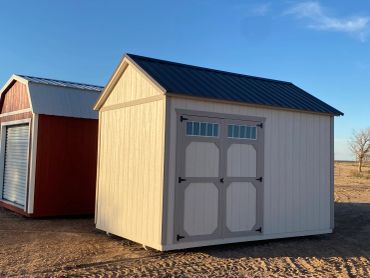 A beige wooden storage shed with a black roof.