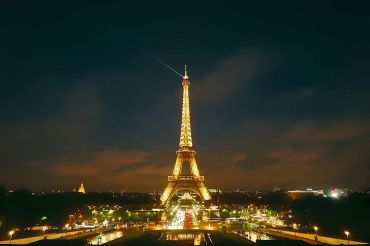 The Eiffel Tower glowing brightly at night in Paris.