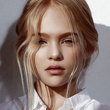 Close-up portrait of a young blonde woman with loose hair.