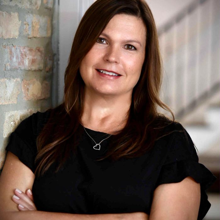 Stack of books next to pencils in a holder and a camera.