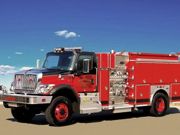 A firetruck is silhouetted against a blue sky.