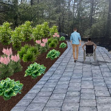 Man walking beside a person in a wheelchair on a paved path with garden plants.