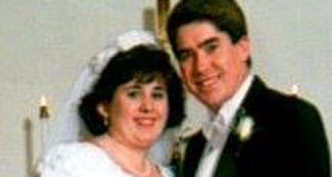 A bride and groom smiling on their wedding day.