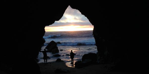 Hikers in one of the many caves of Point Reyes on a backpacking tour.