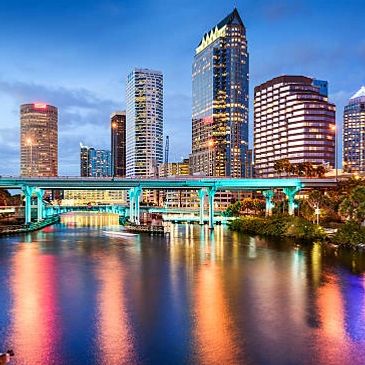 City skyline at dusk with colorful reflections on the water.
