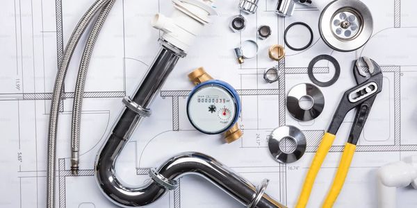 Plumbing tools and parts arranged on a blueprint for installation.