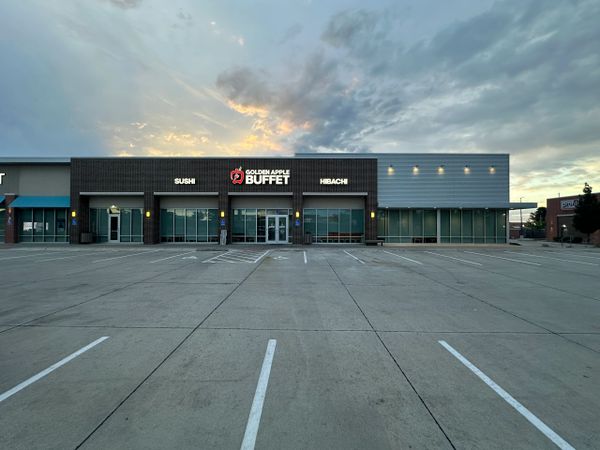 Exterior of Golden Apple Buffet restaurant at dusk with empty parking lot.