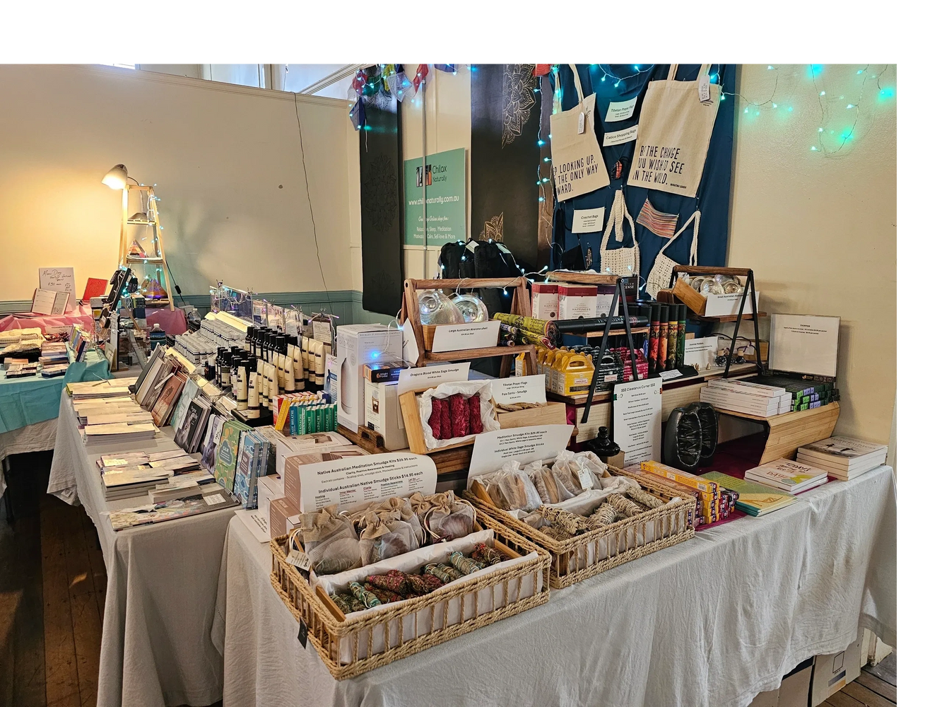 Chilax Naturally. Indoor market stall displaying various wellness and meditation products with cozy lighting. Copyright Lynise Fisher 2025