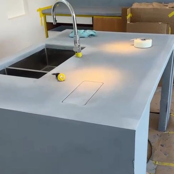 Modern kitchen island with sink and faucet under construction.