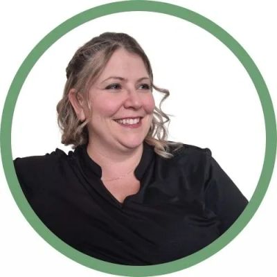 Femme souriante aux cheveux bouclés dans un cadre vert.