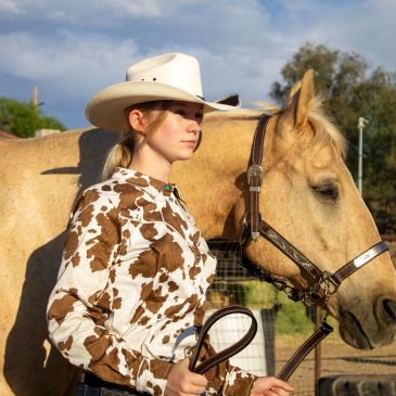 Woman in cowboy hat with a horse.