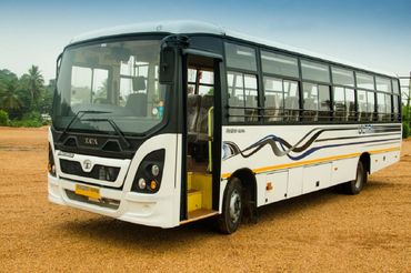 White Tata Starbus Ultra parked on a dirt ground with open door.