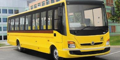 A yellow school bus parked near a modern building.