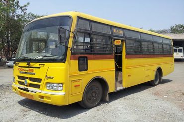 Yellow school bus parked with open door on a sunny day.