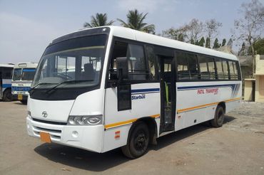 White Tata Starbus bus labeled Patil Transport parked with open door.