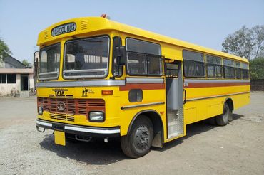 Yellow school bus parked with open door in a sunny outdoor area.