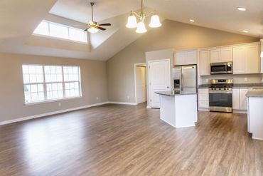Open floor plan photo with vaulted ceilings and windows.