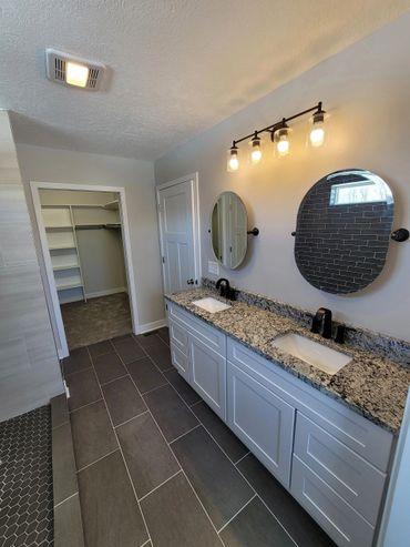 Master bathroom with granite countertops and tiled flooring.