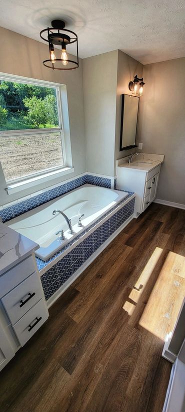 Master bathroom soaking tub with tile surround.