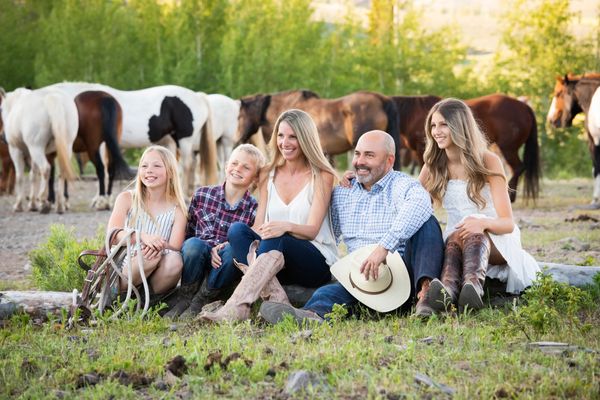 Lifestyle Family Portrait Session on location in Colorado Rocky Mountains with horses in background.