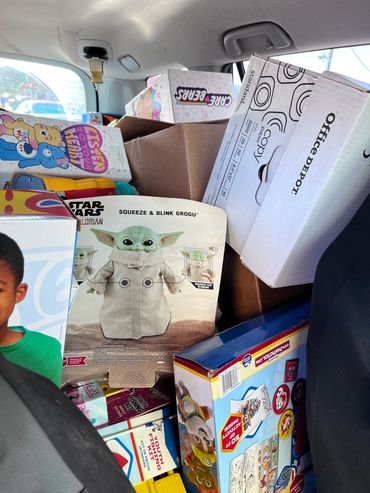 Car filled with boxes of toys and office supplies.
