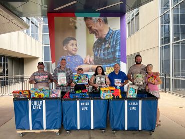 Group of people donating toys at a Child Life hospital event.