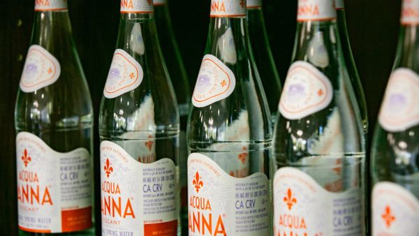 Multiple Acqua Panna mineral water bottles lined up in a row.