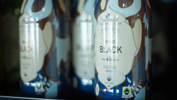 Bottles of organic black iced tea with blue and brown design.