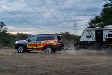 TOYOTA LANDCRUISER TOWING A CARAVAN ON DUSTY ROAD