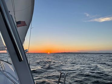 Sunset over the water seen from the sailboat