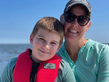 Boy and mom smiling while sailing
