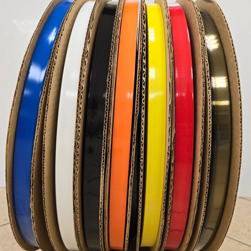 Colorful rolls of tape or filament arranged in cardboard holders.