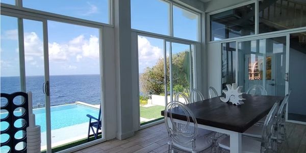 Dining area with ocean view and pool outside.