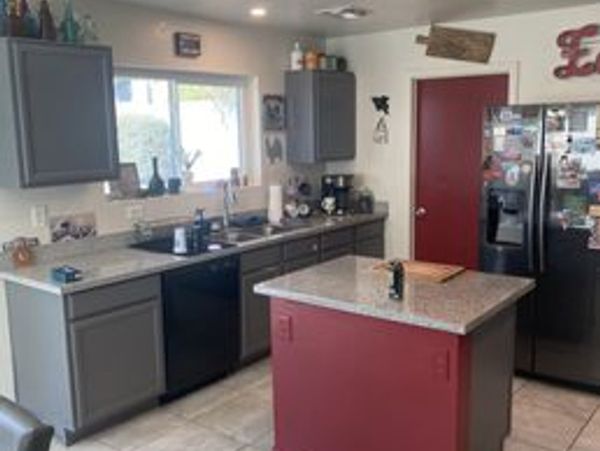 Modern kitchen with gray cabinets and a red island.